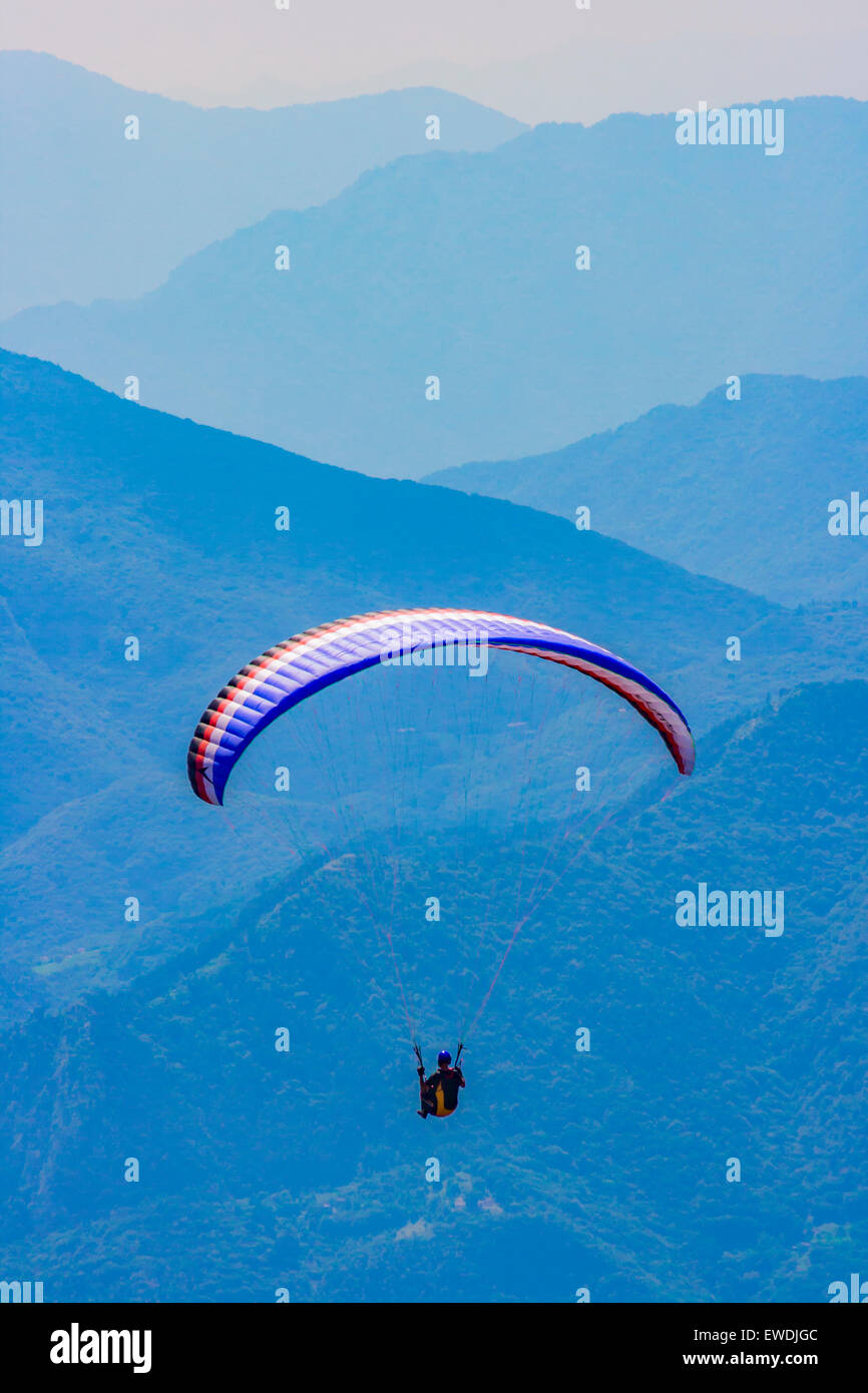 Parapendio sopra il lago italiano, Garda, al di sopra di Malcesine con le colline fantasma in background Foto Stock