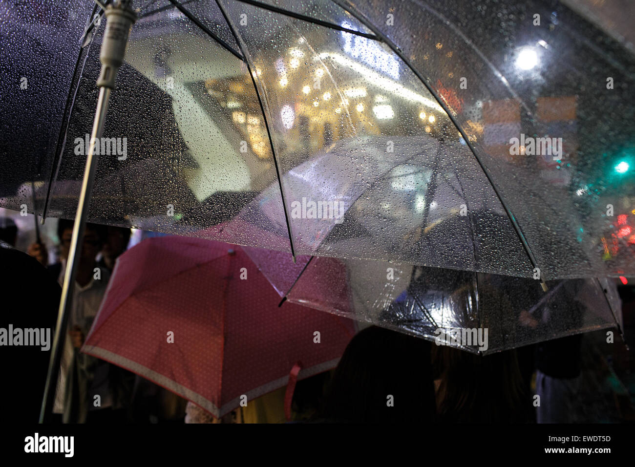 Persone con ombrelli sotto la pioggia in Shibuya di notte a Tokyo in Giappone Foto Stock