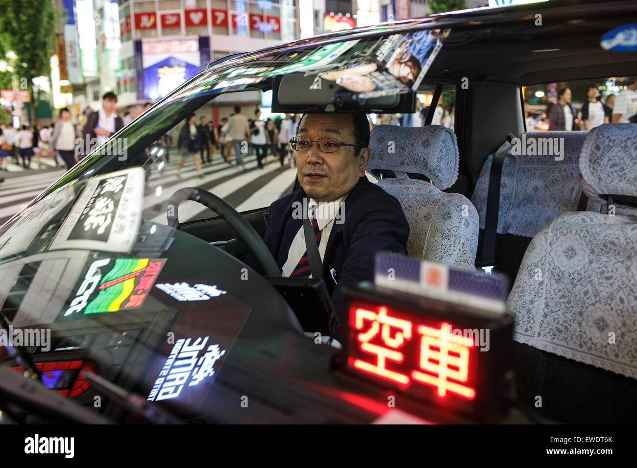 Un tassista dentro la sua macchina di notte di Shinjuku, Tokyo, Giappone Foto Stock