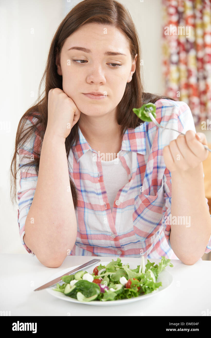 Ragazza adolescente sulla dieta mangiare piatto di insalata Foto Stock
