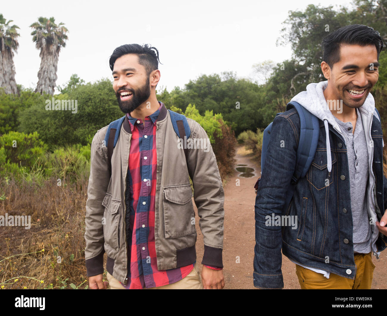 Due sorridenti giovani uomini a camminare in un parco Foto Stock