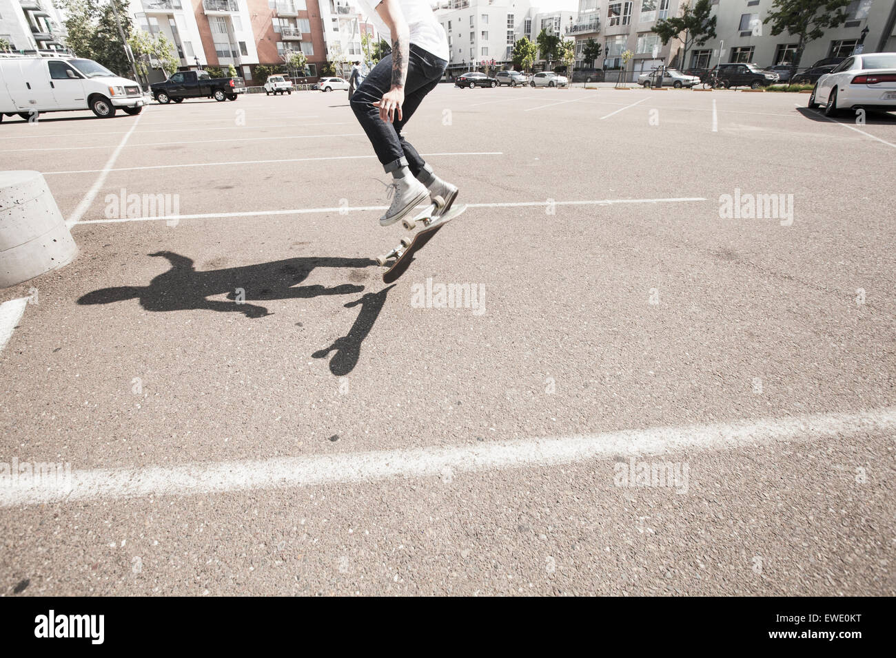 Giovane uomo lo skateboard in un parcheggio Foto Stock