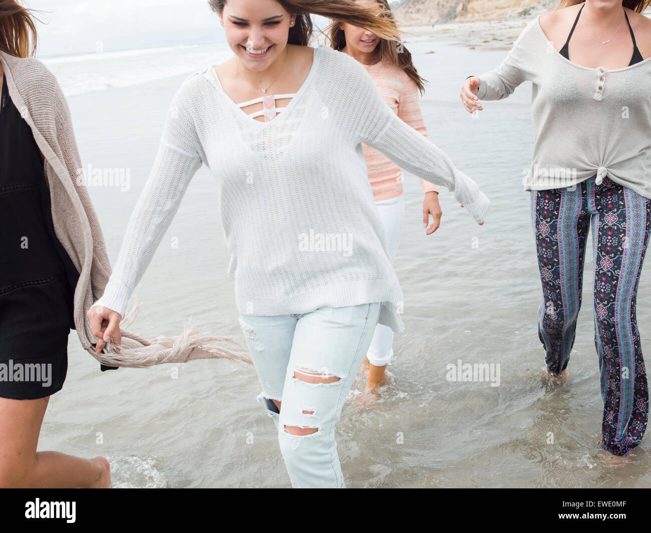Un gruppo di sorridere le giovani donne a camminare su una spiaggia Foto Stock