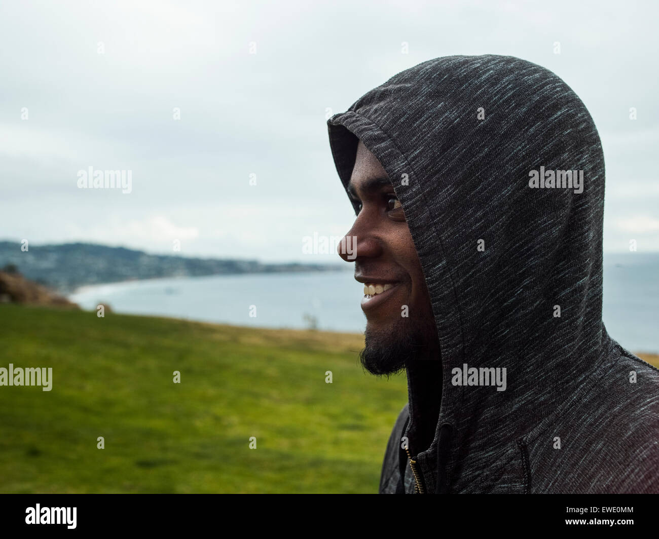 Close up di un sorridente giovani uomini indossare una felpa con cappuccio Foto Stock