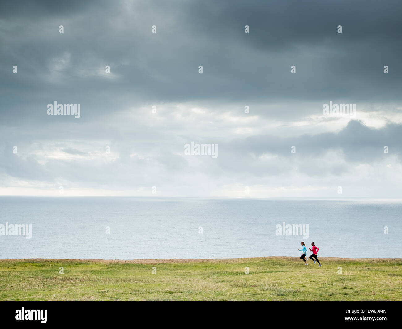 Due donne a fare jogging lungo la costa in guide di scorrimento Foto Stock
