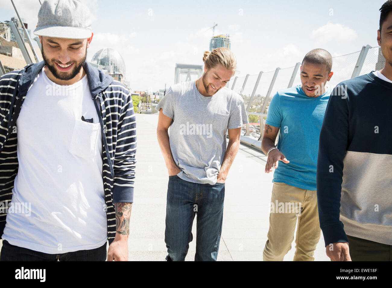 Un gruppo di giovani uomini a camminare lungo la passerella Foto Stock