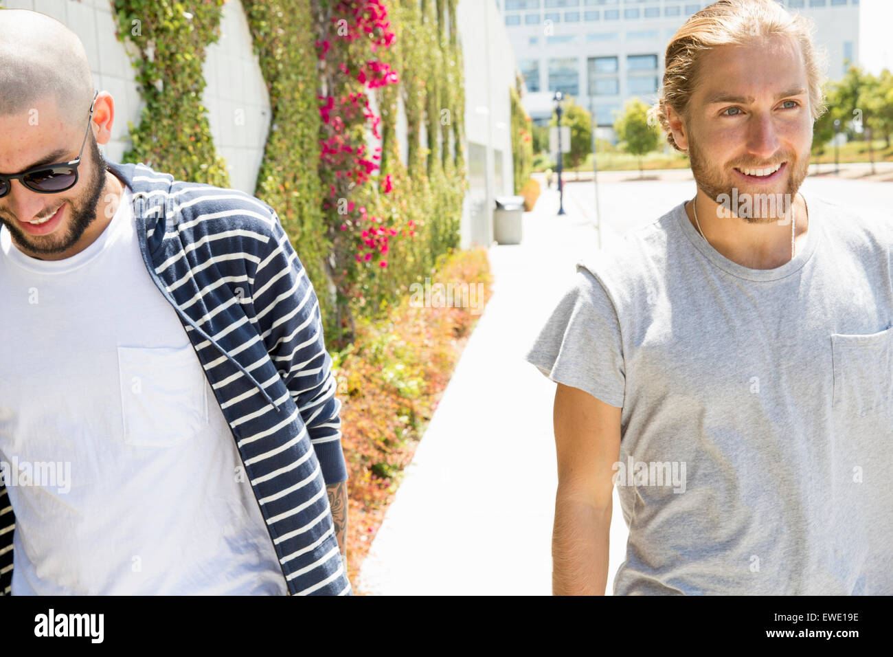 Due sorridenti giovani uomini a piedi lungo un sentiero la vita di strada giovani Foto Stock