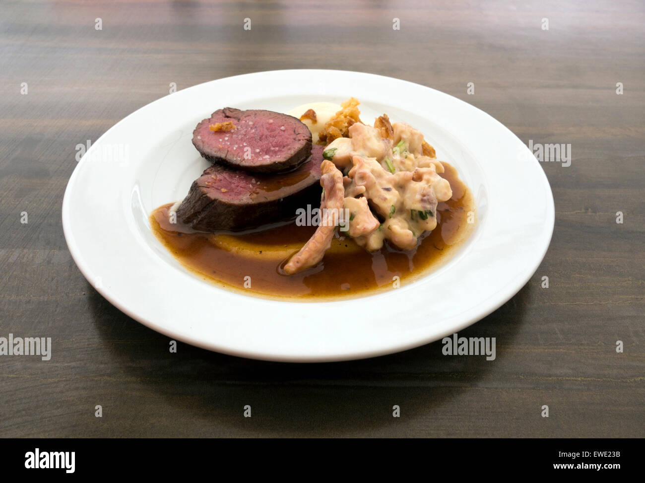 Sella alla griglia di cervi, polpo alla griglia, vestirsi di arancione e rosa lo zenzero, carne di cervo demi-glace Foto Stock