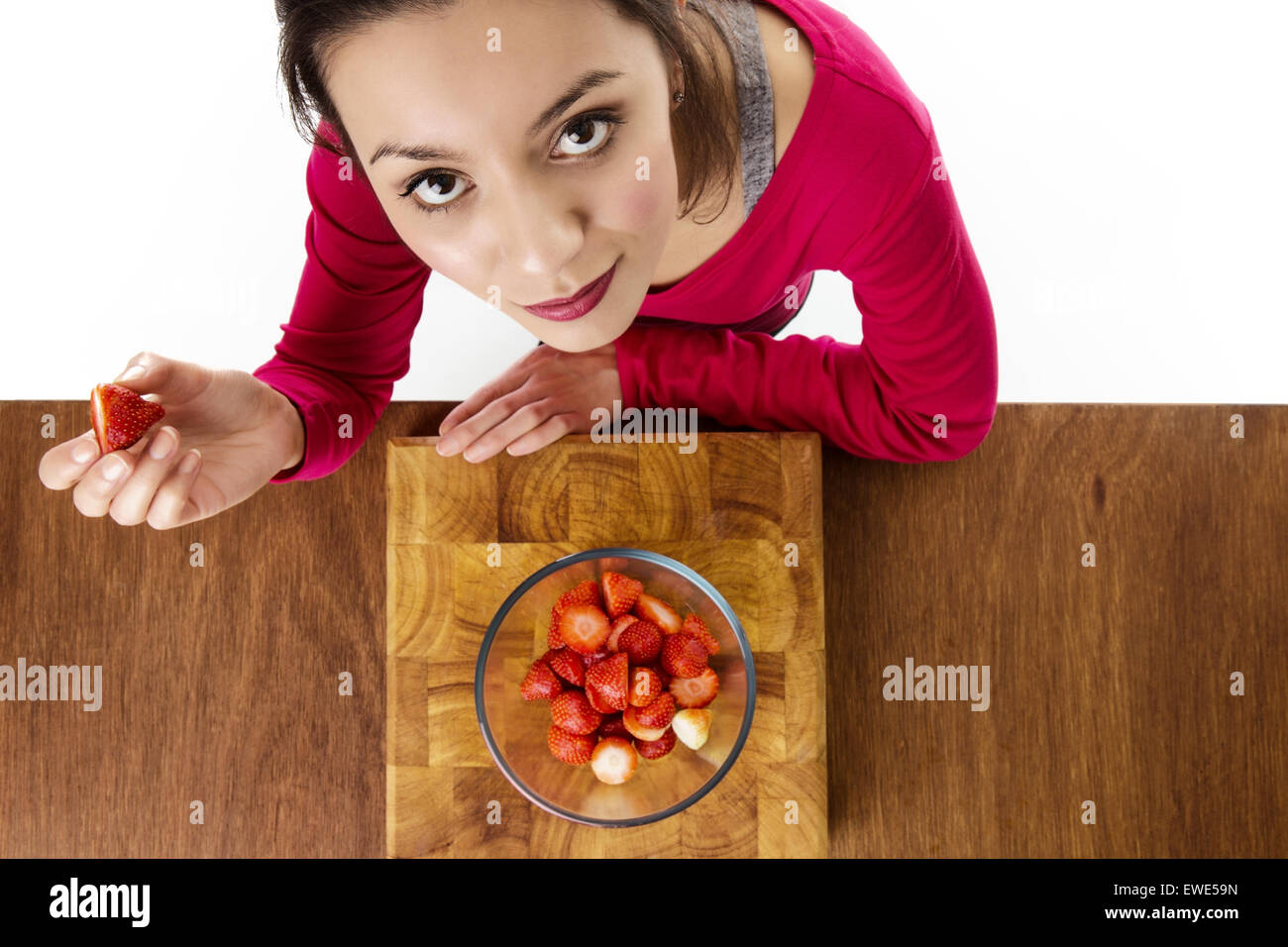 Donna che sta per mangiare fragole presi da un occhio di uccelli sopra vista guardando verso il basso Foto Stock