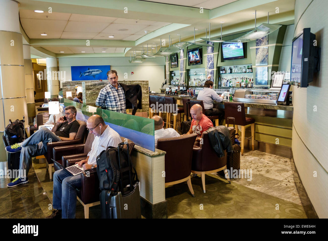 Miami Florida,Aeroporto Internazionale,mia,interno,terminal,gate,American Airlines Admirals Club,lounge,bar lounge pub,pub,posti a sedere,uomo maschile,FL1 Foto Stock