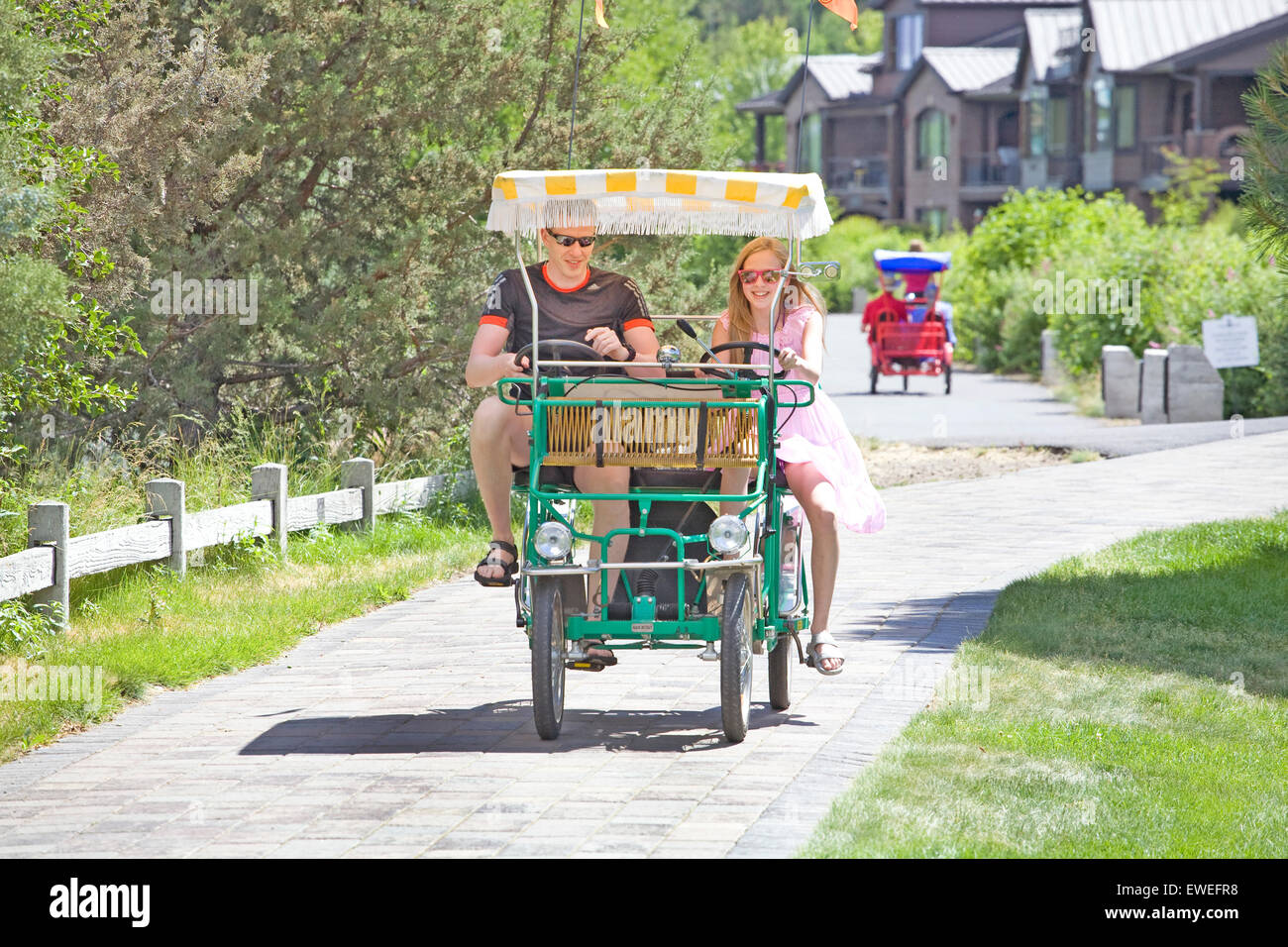 Una gita di famiglia su una bicicletta carrello in un giorno di estate lungo il fiume Deschutes in curva, Oregon Foto Stock