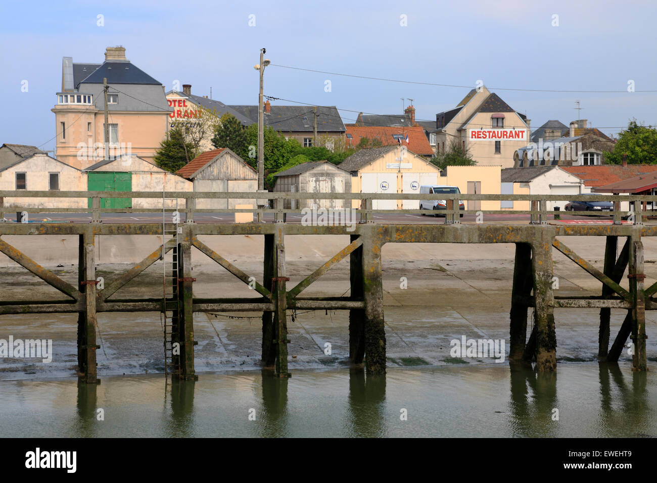 Ponte o molo nel porto di Grandcamp-Maisy in Normandia, Francia, a bassa marea. Vista sul quartiere del porto. Foto Stock