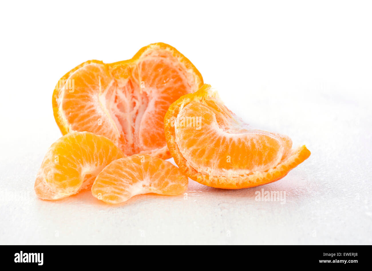 Mandarino dolce metà con segmenti su bianco rustico shabby chic tavolo. Foto Stock