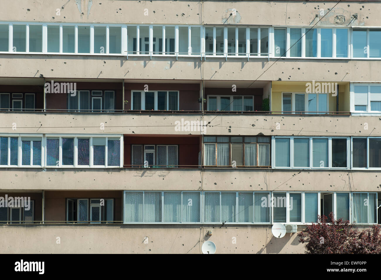 La facciata di un edificio con segni di colpi di arma da fuoco sui muri di Sarajevo Foto Stock