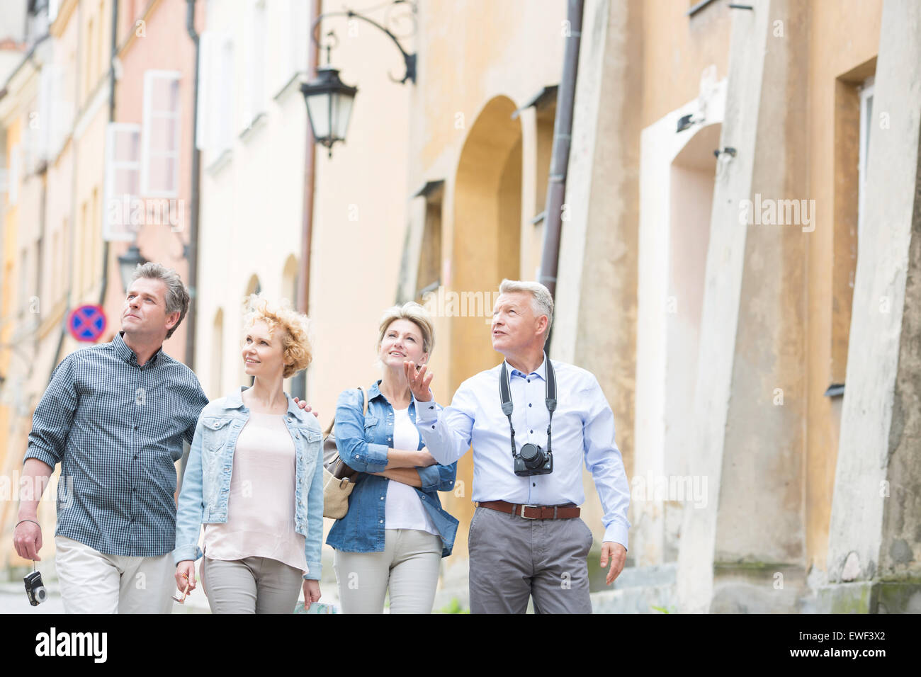 Happy amici parlando mentre passeggiate in città Foto Stock