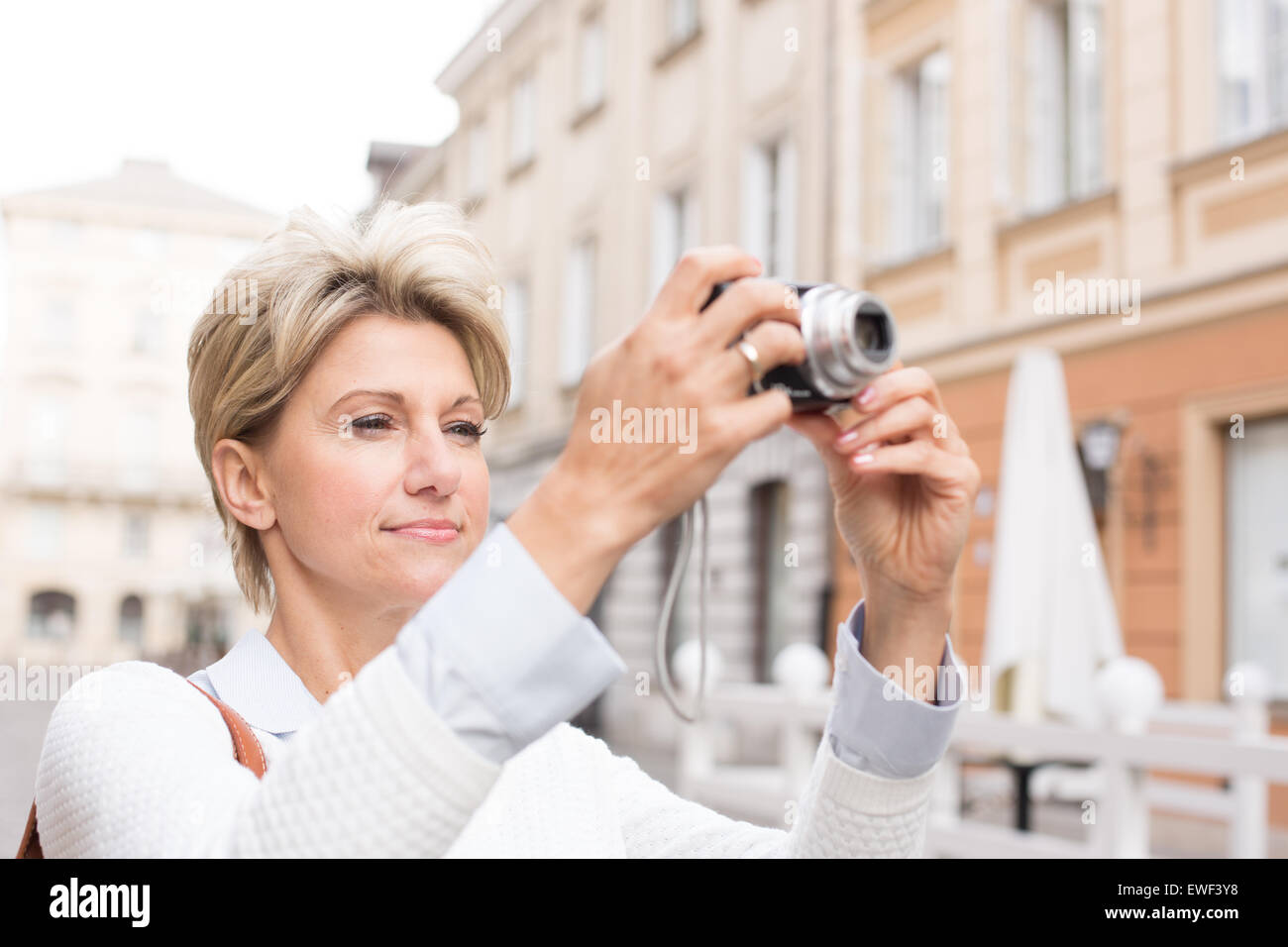 Donna fotografare attraverso la fotocamera digitale in città Foto Stock