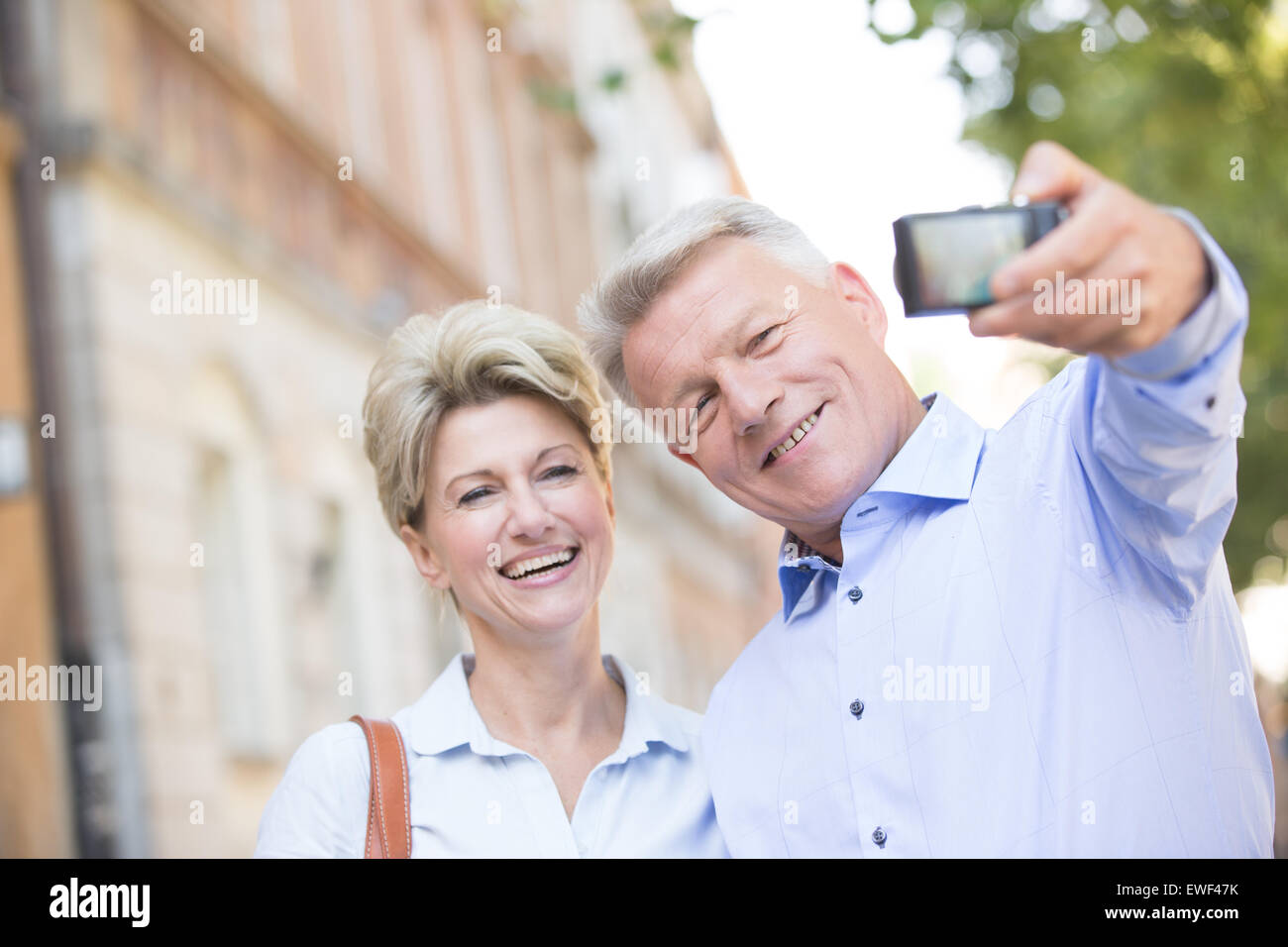 Allegro di mezza età giovane tenendo ritratto di auto all'aperto Foto Stock