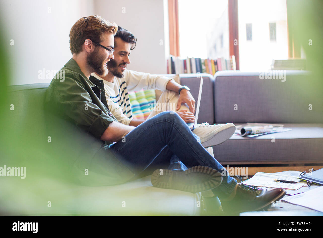 Gli imprenditori informali utilizzando computer portatile sul divano Foto Stock
