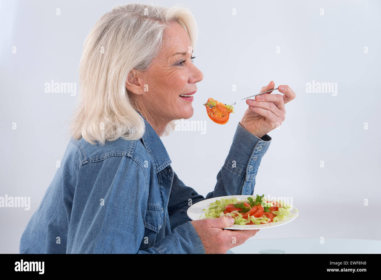 SENIOR di mangiare verdura cruda Foto Stock