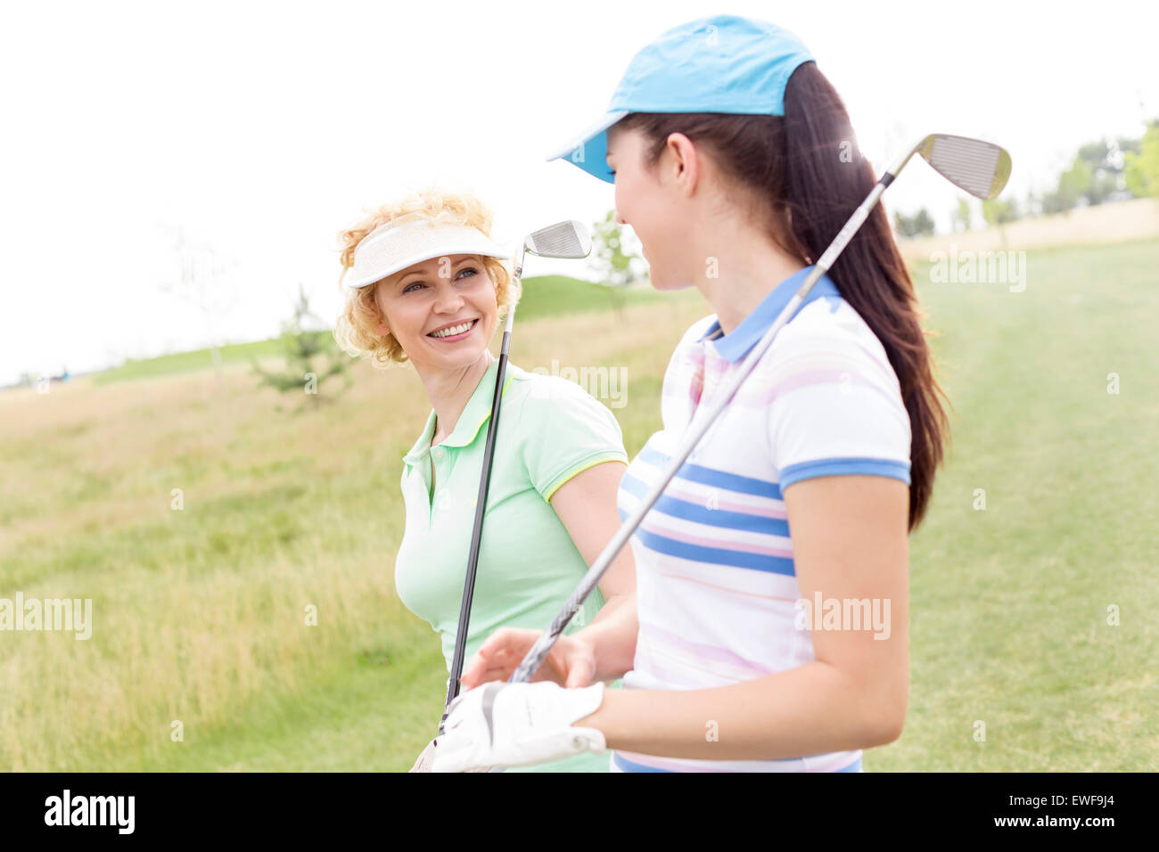 Felice golfisti femmina parlando a campo da golf Foto Stock