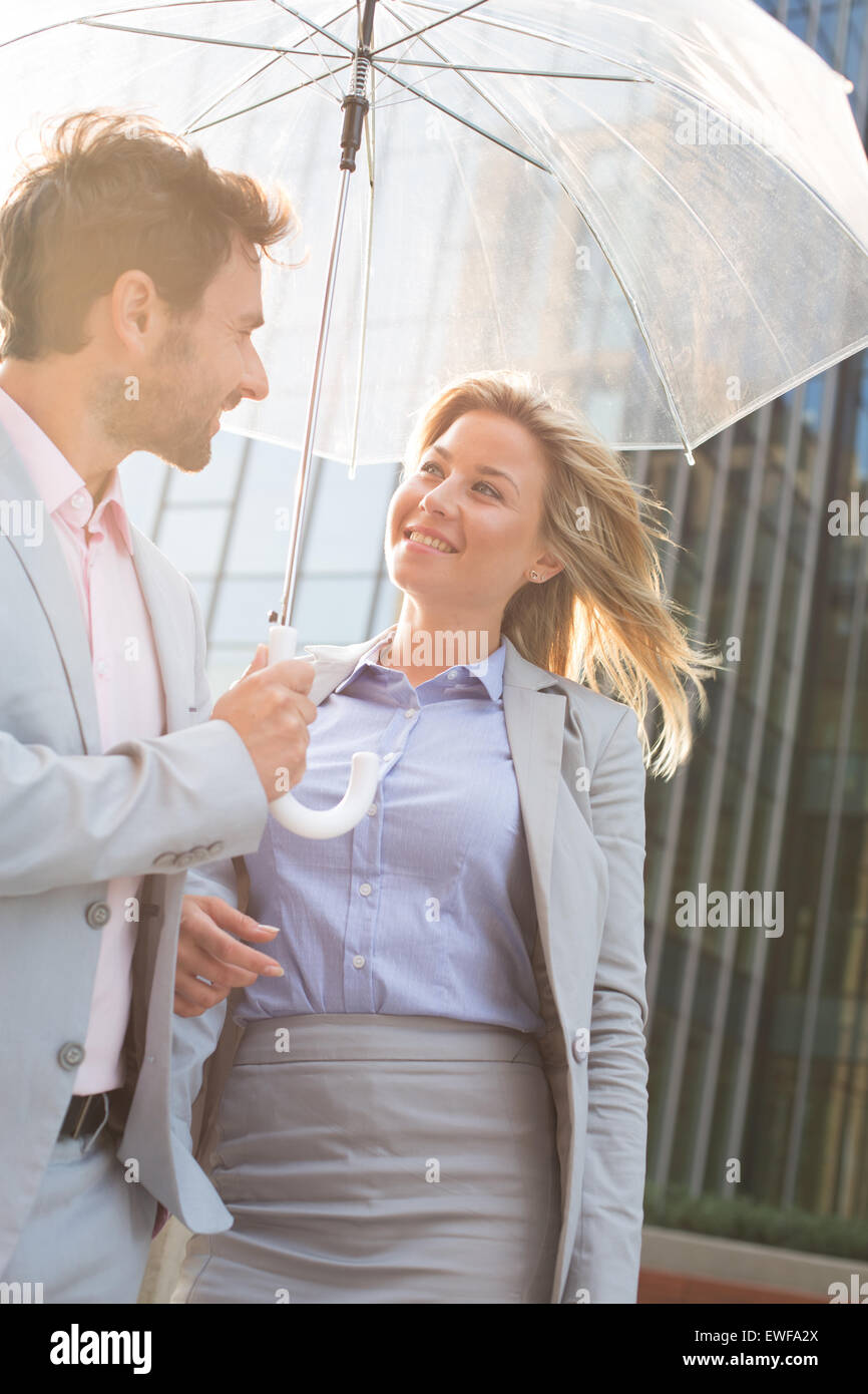 Happy business giovane conversando sotto ombrellone esterni Foto Stock