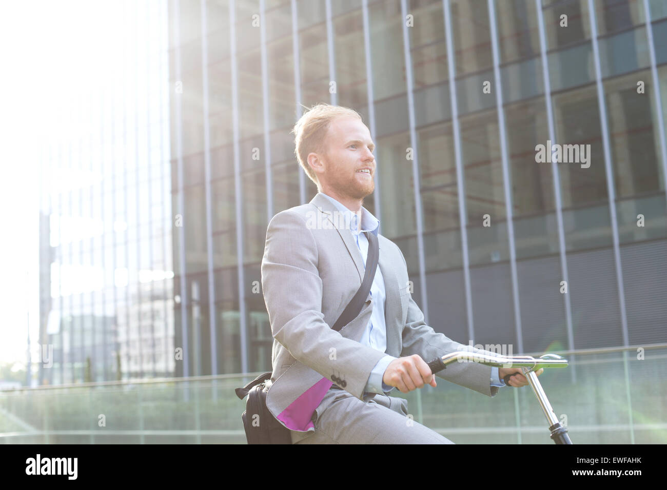Imprenditore Bicicletta Equitazione al di fuori di edificio per uffici Foto Stock