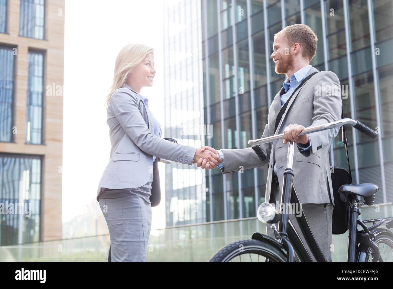 Happy businessman stringe la mano al di fuori di edificio per uffici Foto Stock