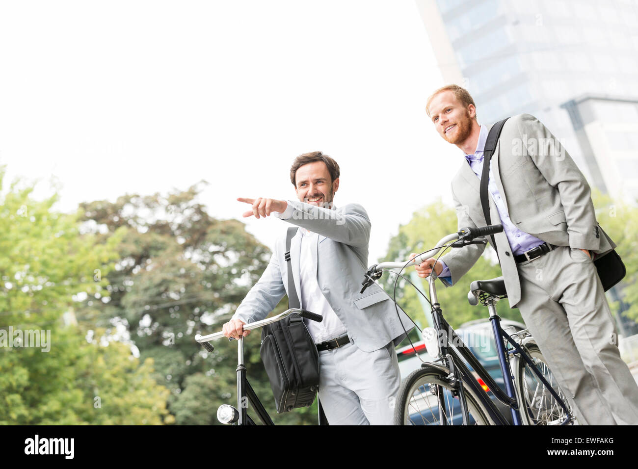 Imprenditore sorridente con noleggio mostra qualcosa a un collega su strada Foto Stock