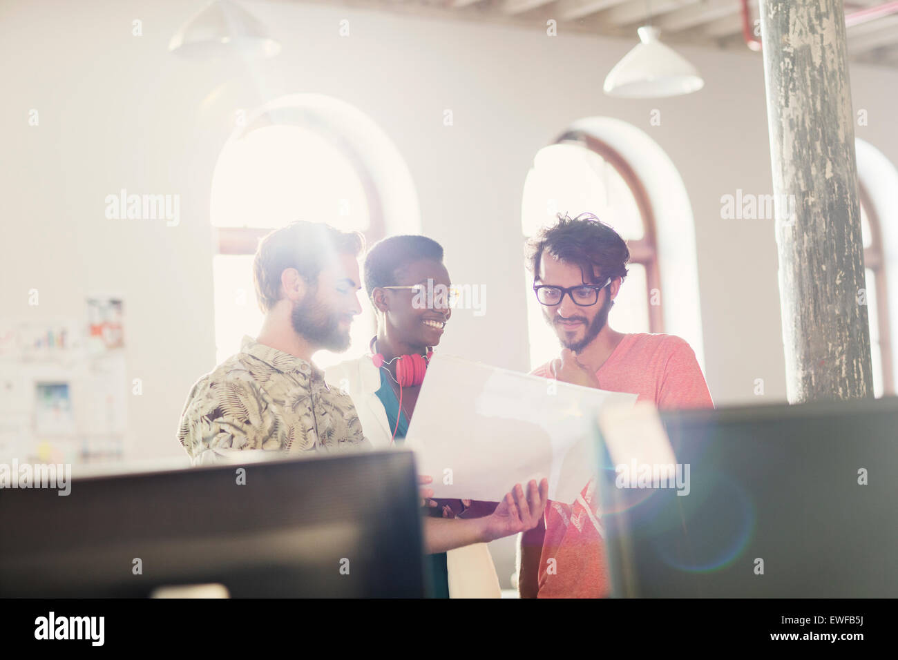 Azienda creativa persone rivedendo la documentazione in sole ufficio Foto Stock