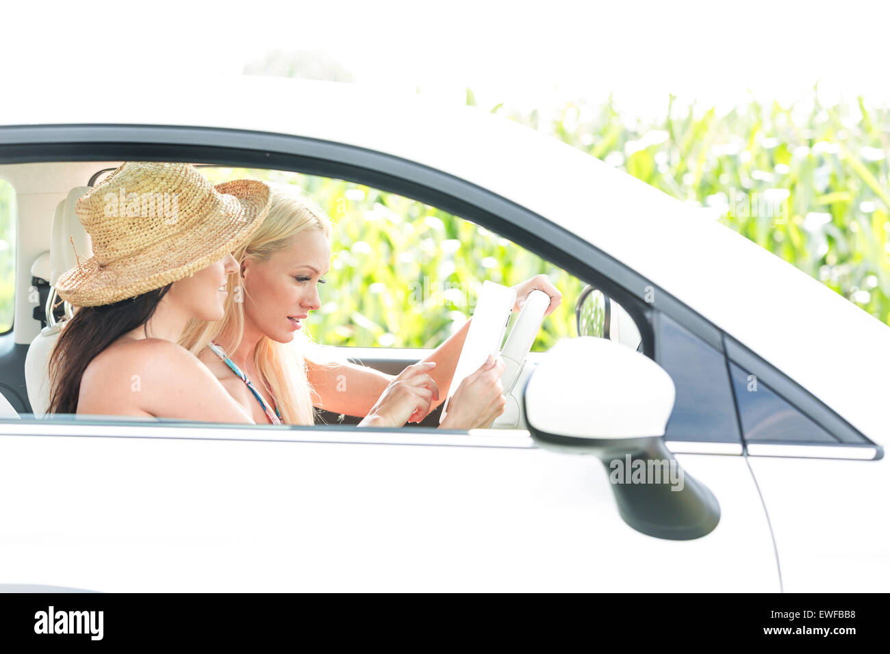 Amici di sesso femminile con tavoletta digitale in auto Foto Stock
