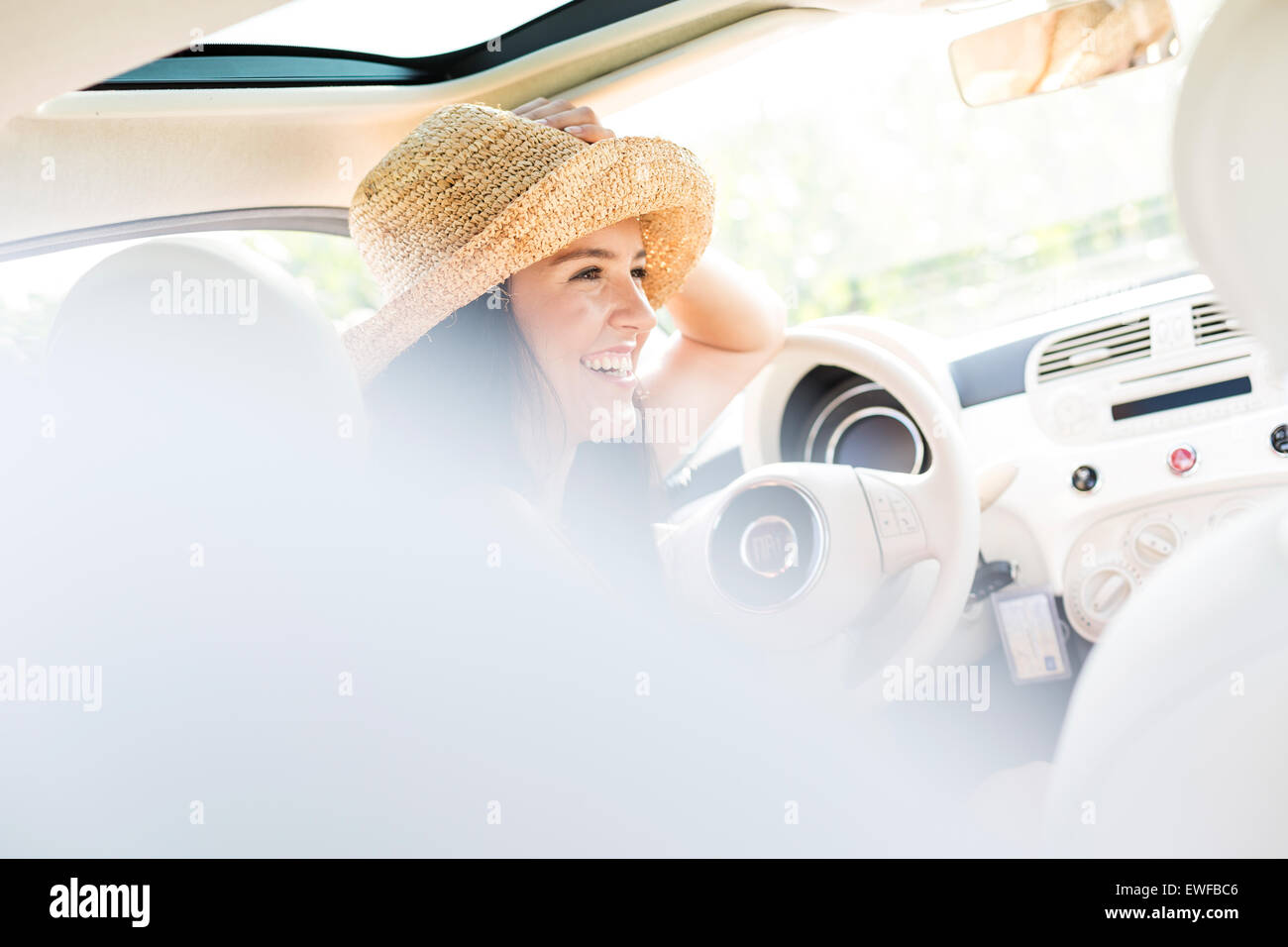 Felice donna seduta in auto Foto Stock