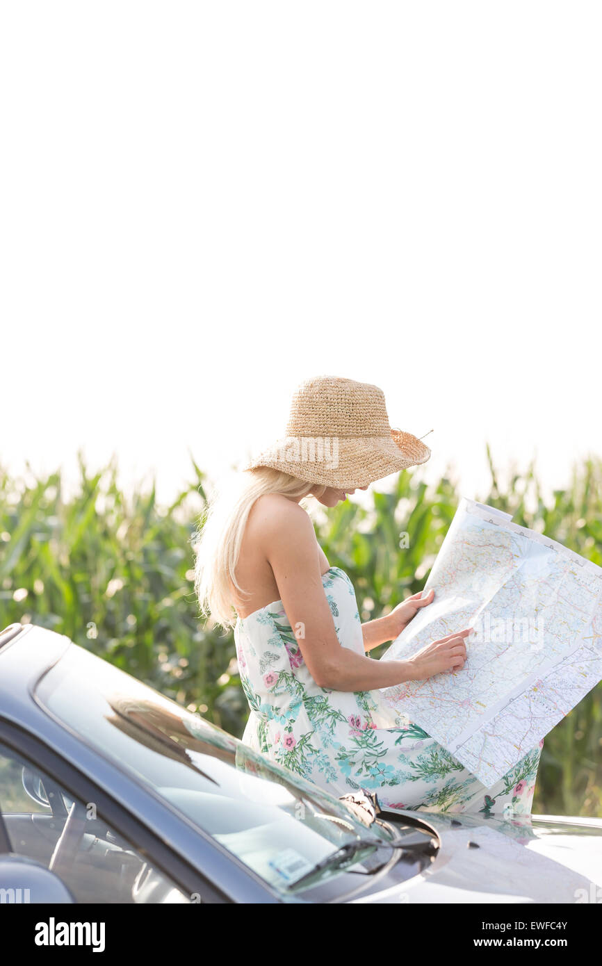 Donna mappa di lettura pur poggiando su cabriolet Foto Stock