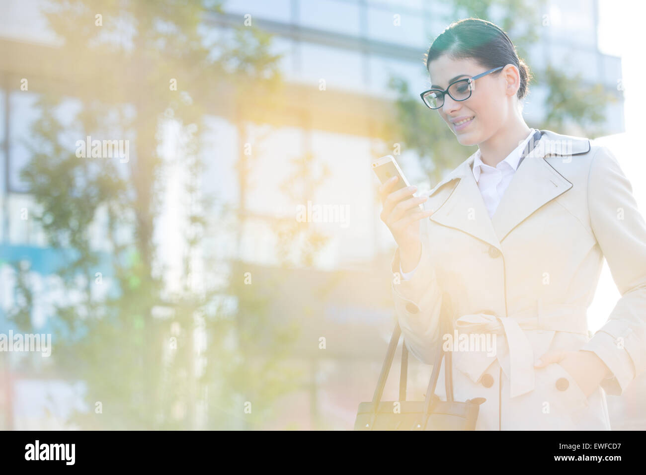 Imprenditrice utilizzando smart phone sulla giornata di sole Foto Stock