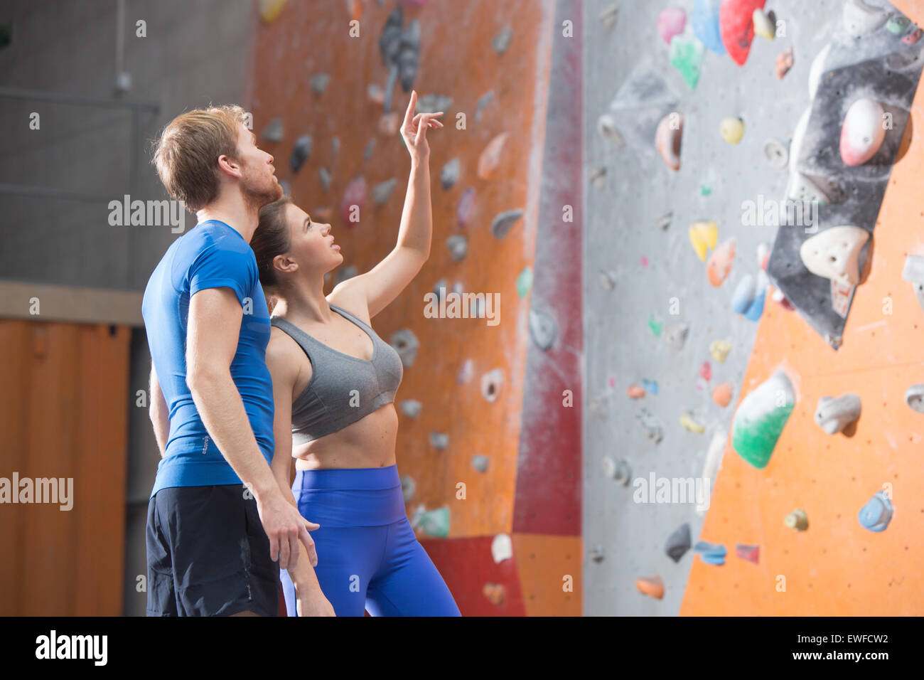 L uomo e la donna a discutere dalla parete di arrampicata in palestra crossfit Foto Stock