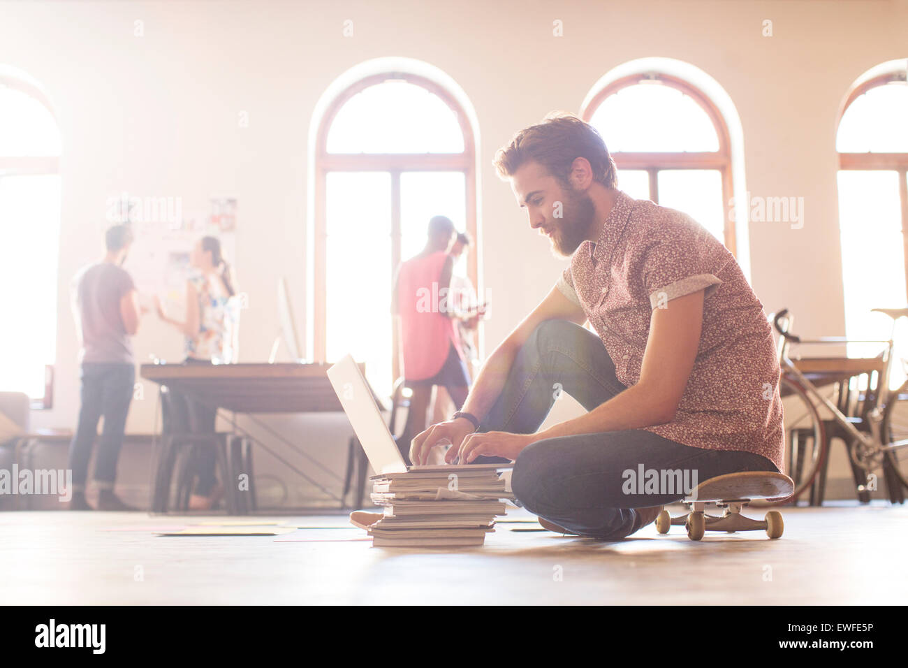 Imprenditore Casual lavora al computer portatile da skateboard Foto Stock