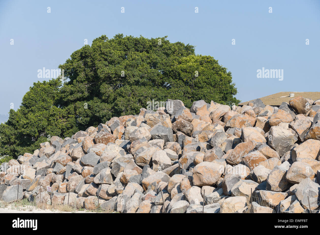 Pila di rocce basaltiche che pronto per la costruzione di una nuova acqua di pausa nel porto, Foto Stock