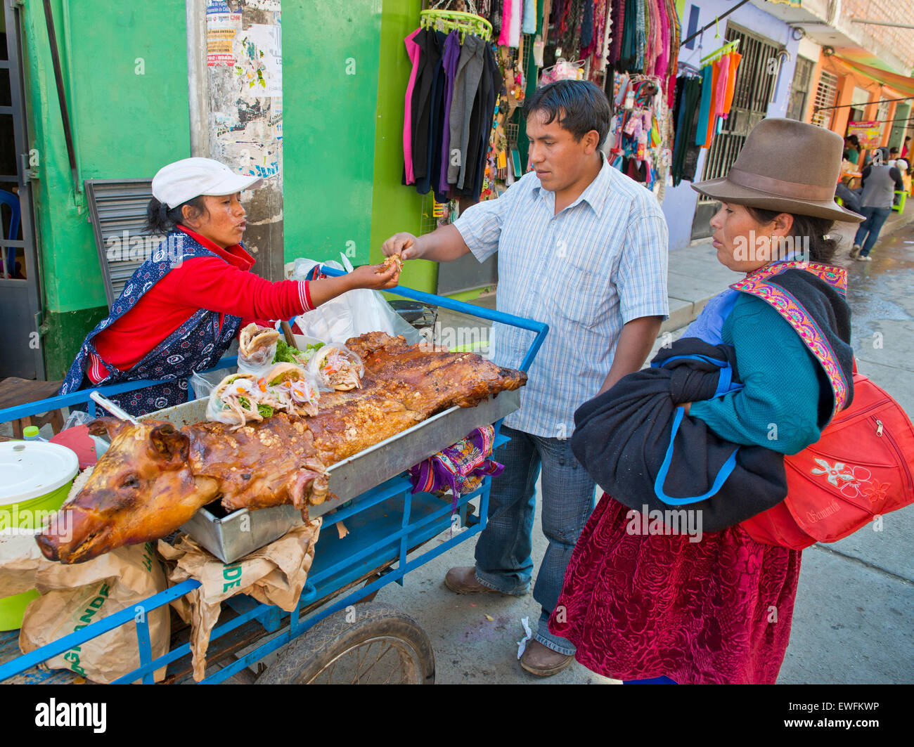 Un Quechua donna indiana la vendita di arrosto di maiale e panini sulla strada, Huaraz, nel nord del Perù, Perù Foto Stock