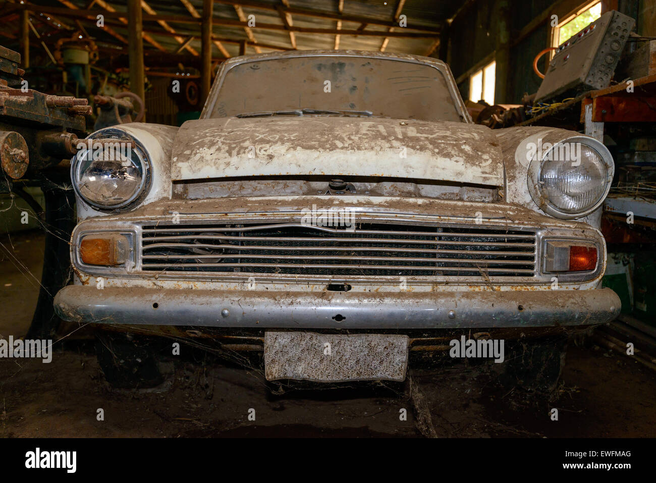 Abbandonato vintage auto coperti con uno strato di polvere nel capannone Foto Stock