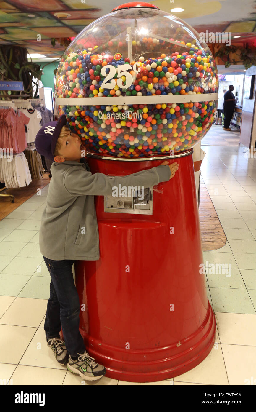 New York, Stati Uniti d'America, ragazzo abbraccia una macchina gumball Foto Stock
