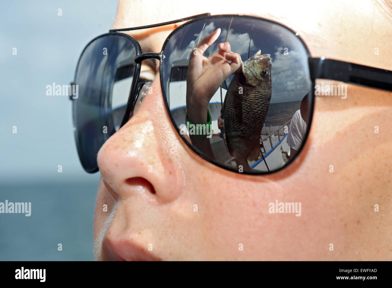 Pete Beach, Stati Uniti, anche la pesca di pesci si riflette negli occhiali da sole di un giovane ragazzo Foto Stock