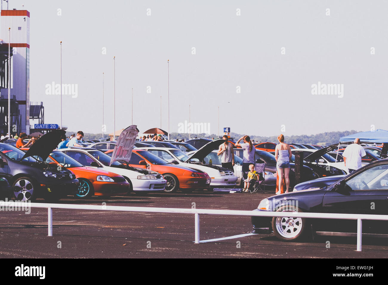 Un gruppo di persone che esaminano le auto con le calotte in un lotto di auto, in genere per scopi di vendita, manutenzione o ispezione. Foto Stock Un gruppo di persone che esaminano le auto con le calotte in un lotto di auto, in genere per scopi di vendita, manutenzione o ispezione. Foto Stock