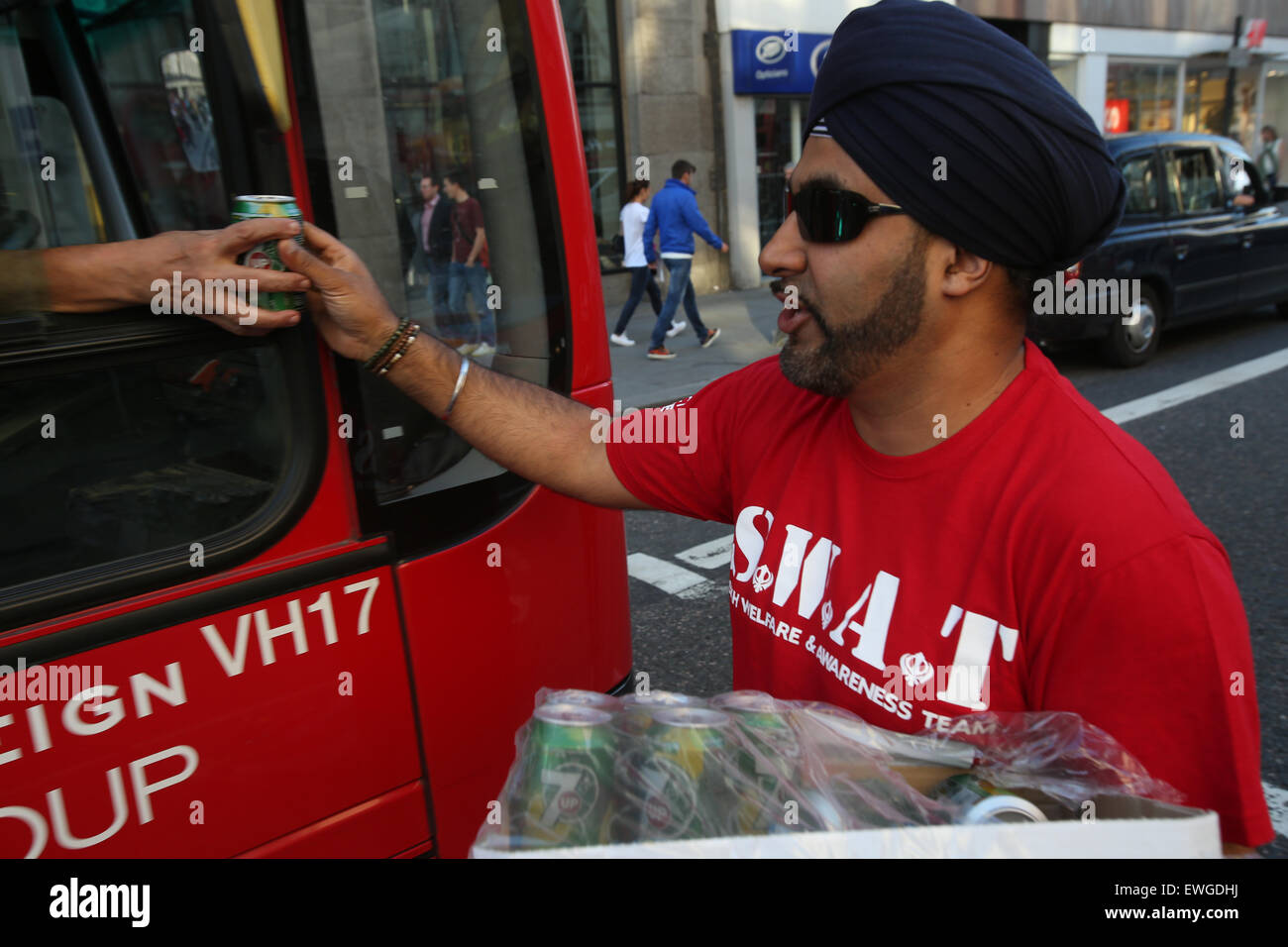 Londra, Regno Unito, 25 giu 2015 - S.W.A.T Sikh (Sikh il benessere e la consapevolezza del team volontari) out invece bevande fredde e volantini come parte della settimana Chabeel commemorazioni in WC2, Londra Centrale Credito: Finn Nocher/Alamy Live News Foto Stock