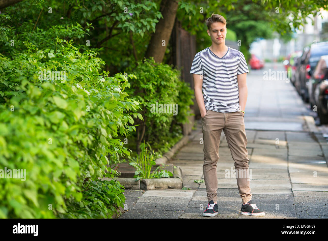 Giovane uomo in piedi sulla strada estiva ritratto in piena crescita. Foto Stock