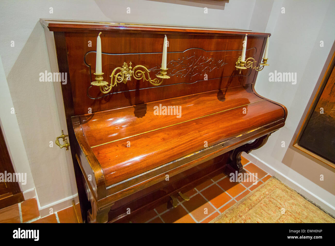 Antico pianoforte con tasti in avorio e antichi lampadari per illuminare Foto Stock