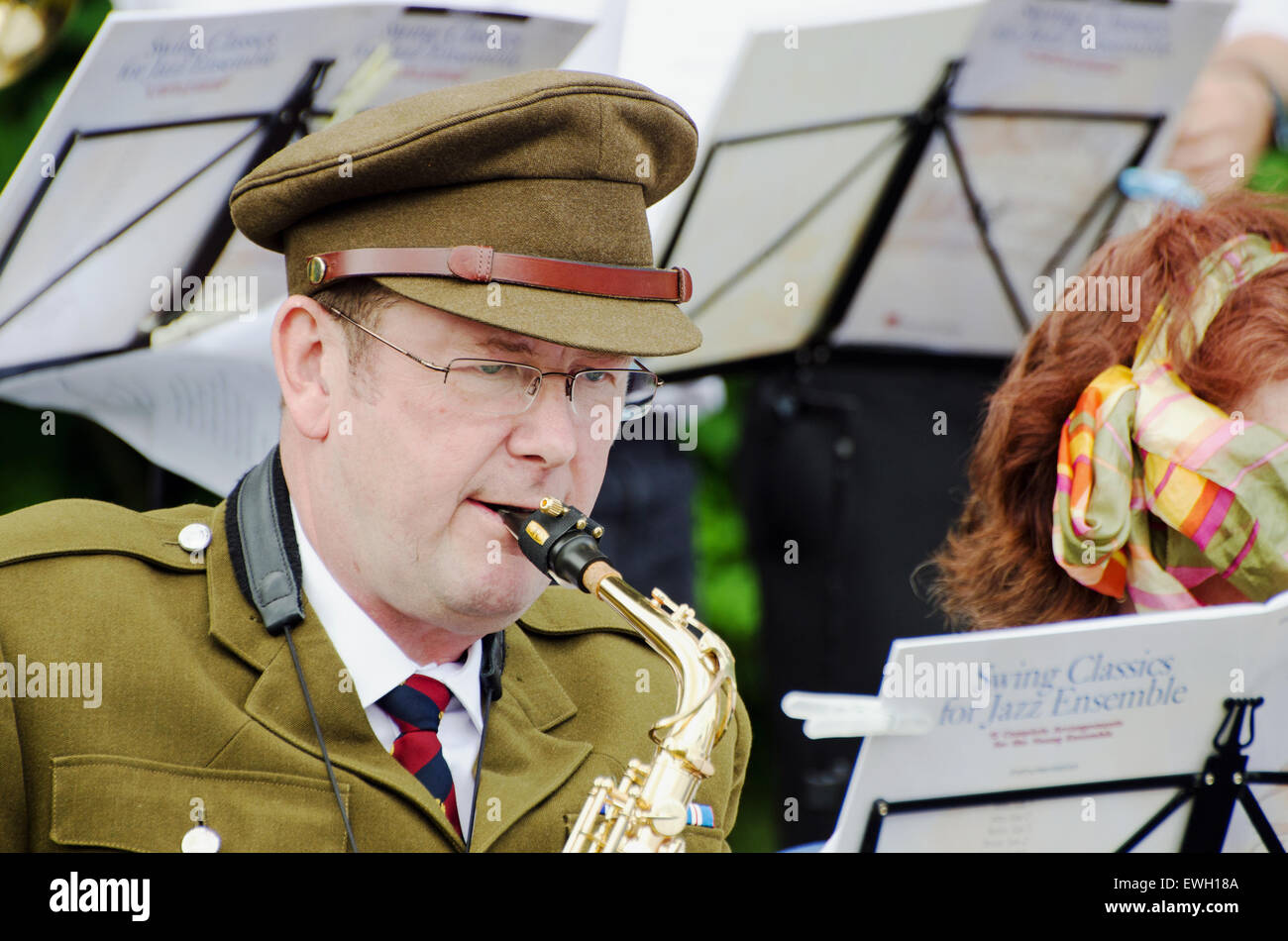 Close-up di un uomo che indossa 1940's esercito britannico uniforme e la riproduzione di un sassofono in una banda di oscillazione. Prese a 1940's rievocazione. Foto Stock