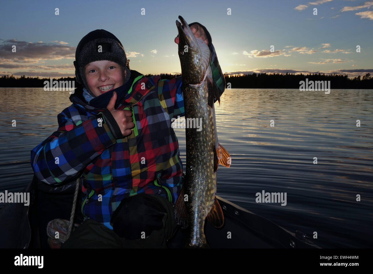 Lessebo, Svezia, ragazzo mostra con orgoglio il suo self-catturati pike sul lago Rottnen Foto Stock