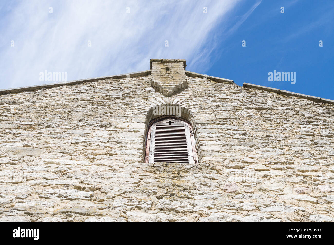 La facciata della chiesa medievale con finestra e forma di croce nella parete Foto Stock