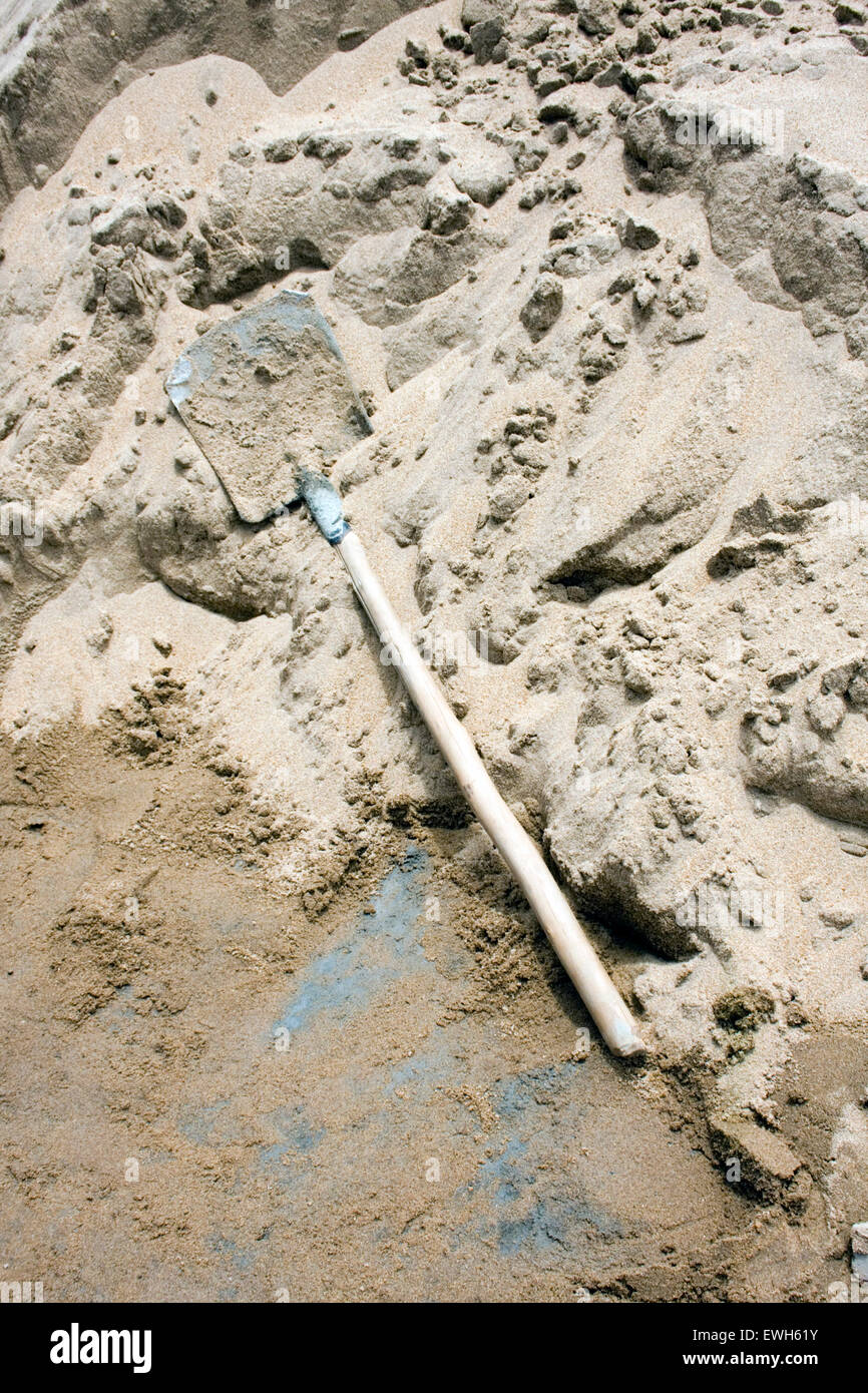 Una pala è stato abbandonato su un mucchio di sabbia in un cantiere in Kampong Cham, Cambogia. Foto Stock