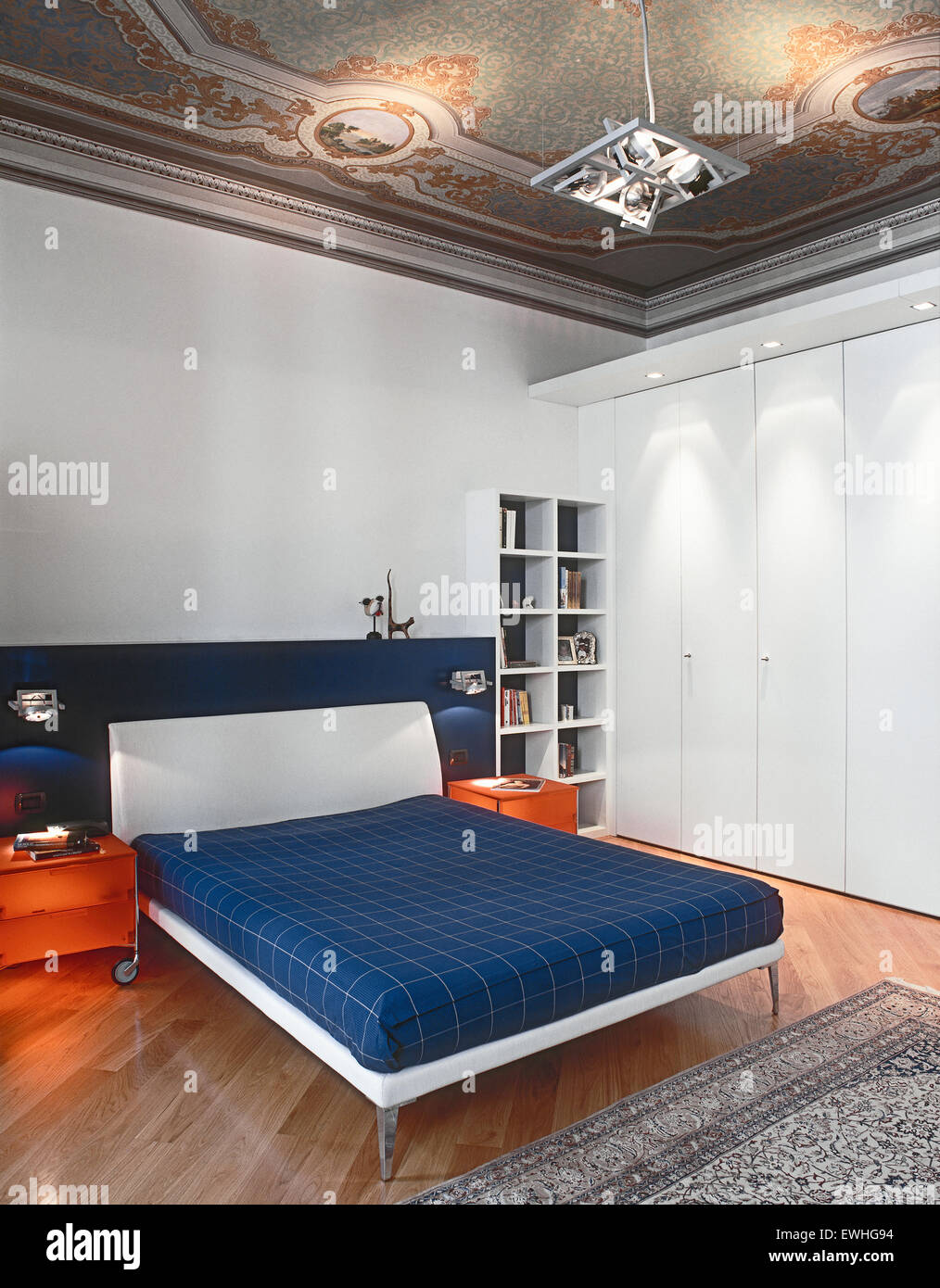 Vista interna di una moderna camera da letto con affresco e pavimento in legno Foto Stock