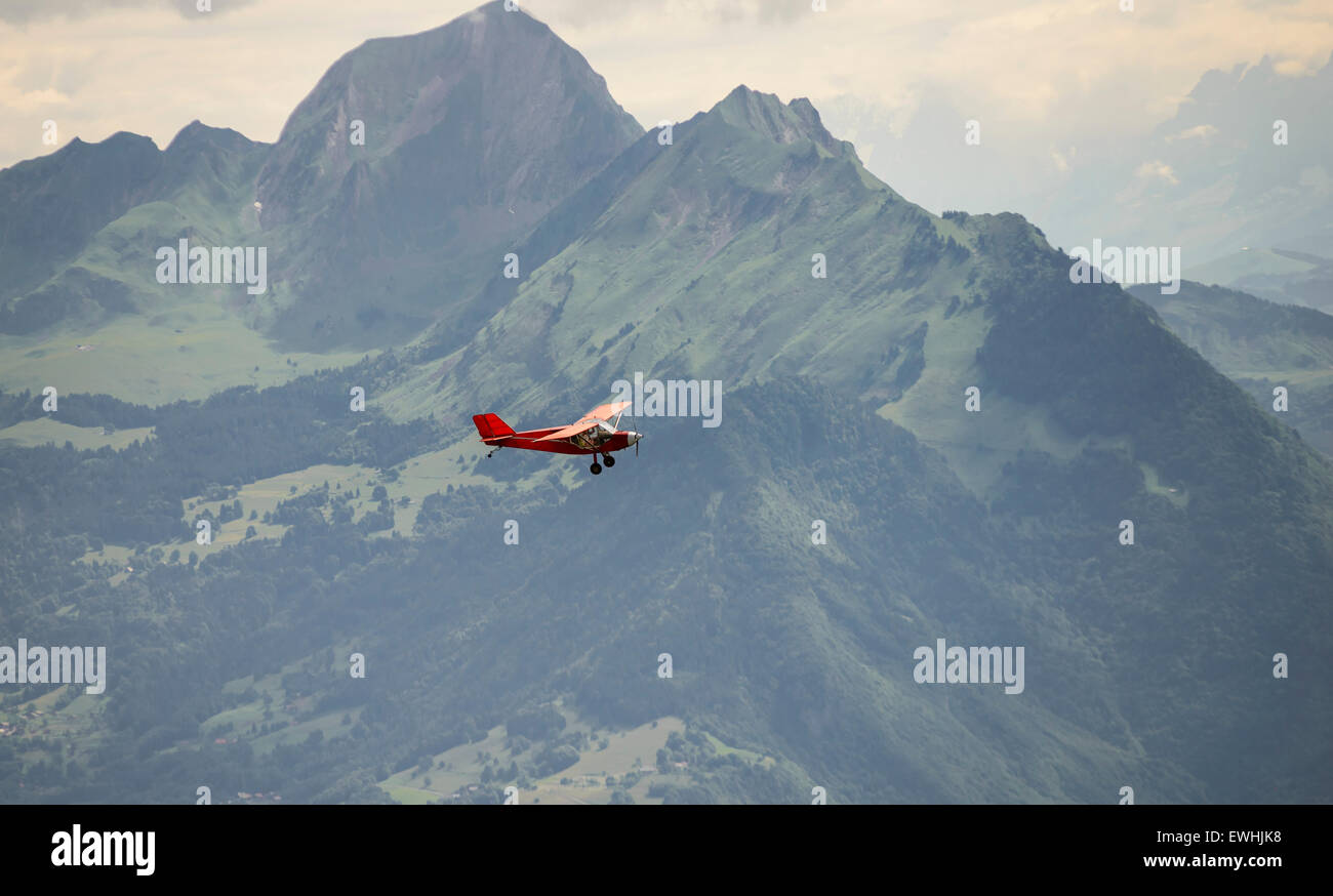 Un piccolo aereo rosso volare sopra le Alpi francesi Foto Stock